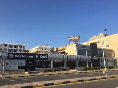 a building with a restaurant and cafe on a city street at Good place to enjoy vacation in Hurghada