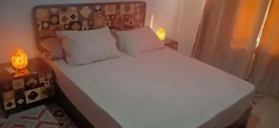 a bed with white sheets and pillows in a bedroom at Good place to enjoy vacation in Hurghada