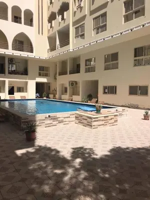 a swimming pool in front of a large building at Good place to enjoy vacation in Hurghada