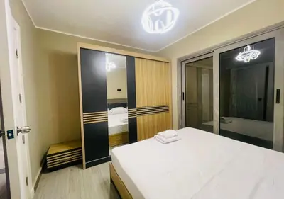 a bedroom with a white bed and a large mirror at Comfort 3BR Apartment C1-D with Private Heated Pool at Bali Elgouna in Hurghada