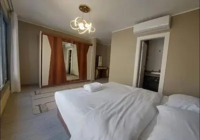 a bedroom with a large white bed and a mirror at Comfort 3BR Apartment C1-D with Private Heated Pool at Bali Elgouna in Hurghada