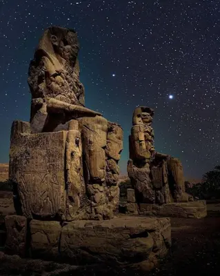 a starry sky with two statues at night at King TuT house in Luxor