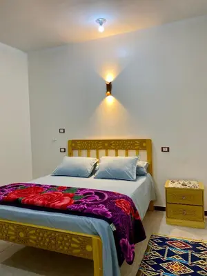 a bedroom with a large bed with a colorful blanket at King TuT house in Luxor