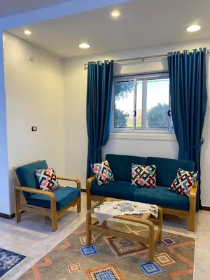 a living room with a blue couch and two chairs at King TuT house in Luxor