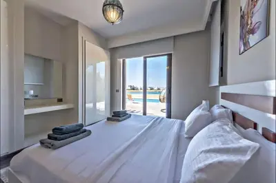 a bedroom with a large white bed with a view of a pool at Villa luxury 5bedroom in gouna in Hurghada