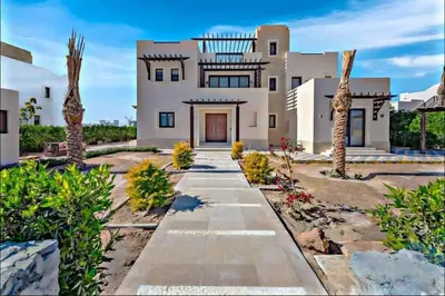a large white house with palm trees and a pathway at Villa luxury 5bedroom in gouna in Hurghada