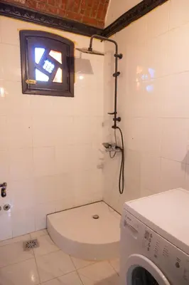 a bathroom with a toilet and a washing machine at Laziza in Luxor
