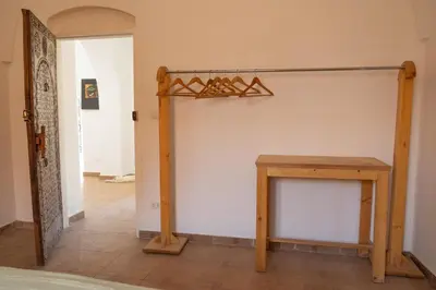 a room with a table and a shelf on the wall at Laziza in Luxor