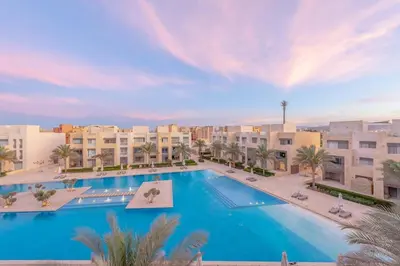 a large swimming pool with buildings in the background at Coastal Vibe 2BR Mangroovy Gouna with Rooftop Cinema, BBQ, Pool & Beach Access in Hurghada