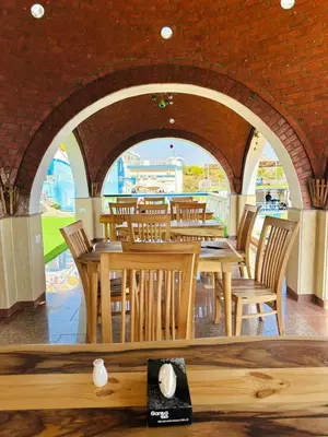 a restaurant with wooden tables and chairs in an archway at Kaya Nubian House in Aswan
