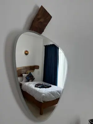 a bedroom with a bed in a round mirror at Kaya Nubian House in Aswan