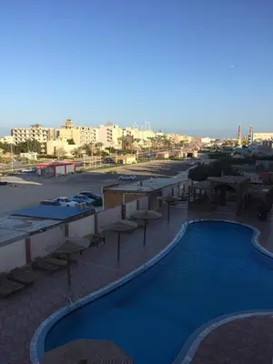 a view of a swimming pool in a parking lot at Cozy Apartment with Red Sea View in Hurghada