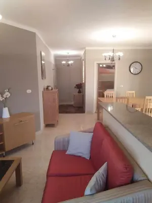 a living room with a red couch and a table at Cozy Apartment with Red Sea View in Hurghada