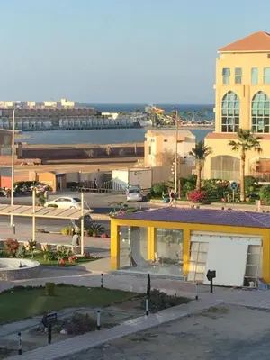 a view of a parking lot with a yellow building at Cozy Apartment with Red Sea View in Hurghada