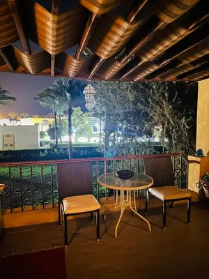 a table and two chairs on a balcony with a mural at شاليه في ستيلا مكادي الغردقة in Hurghada