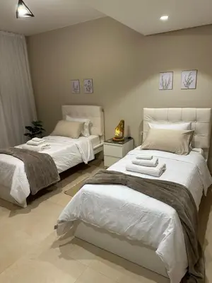 a bedroom with two beds with white sheets at Pool & Sea View 2BR in Mangroovy in Hurghada