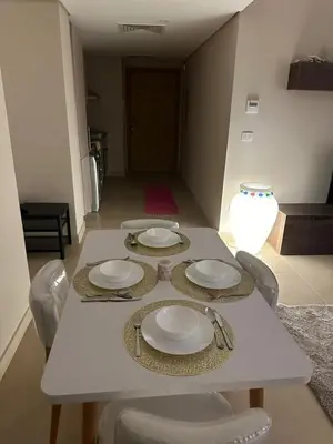 a white table with chairs and plates on it at Pool & Sea View 2BR in Mangroovy in Hurghada