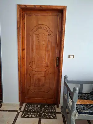 a wooden door with a design on it in a room at Ezba Guest House in Luxor