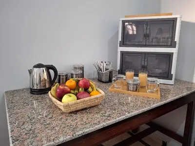 a counter with two baskets of fruit and a microwave at Ezba Guest House in Luxor