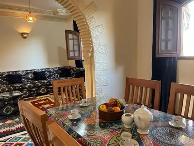a dining room with a table with a bowl of fruit at Habiba Apartment in Luxor