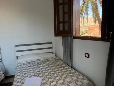 a small bed in a room with a window at Habiba Apartment in Luxor