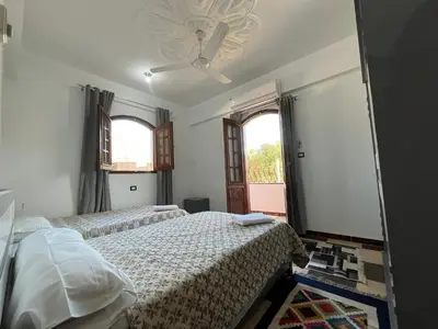 a bedroom with two beds and a window at Habiba Apartment in Luxor