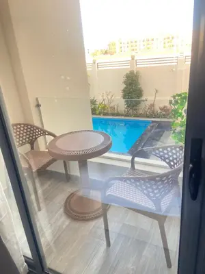 a patio with a table and chairs and a swimming pool at Studio pool view at Imperial Resort Hurghada in Hurghada