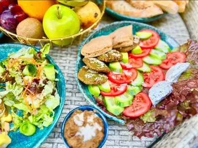 a table topped with plates of salad and fruit at Studio pool view at Imperial Resort Hurghada in Hurghada