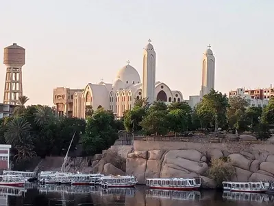 a large building with a bunch of boats in the water at Nile palace in Jazīrat Aswān