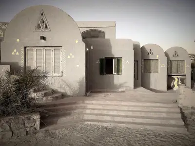 a white building with stairs leading to a door at Shalal Farm and guest house in Aswan