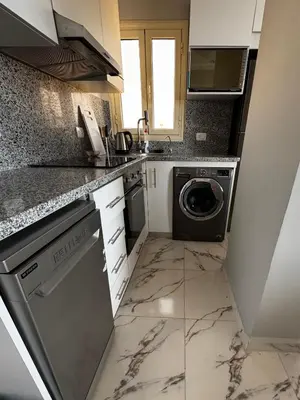 a kitchen with a washer and dryer in it at Seaside Serenity Apartment in Hurghada