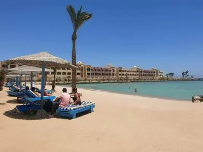 a group of people sitting on the beach at Tiba Golden a in Hurghada
