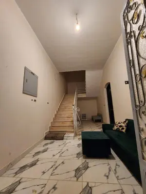 a living room with a staircase and a green couch at Nopian 1 in Luxor