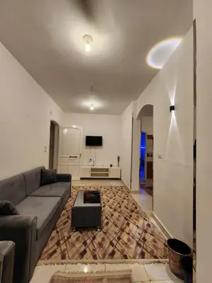 a living room with a couch and a tv at Nopian 1 in Luxor