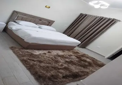 a bedroom with a bed with a brown rug at Private 2BR Apartment with Private Heated Pool at Bali D3 in Hurghada