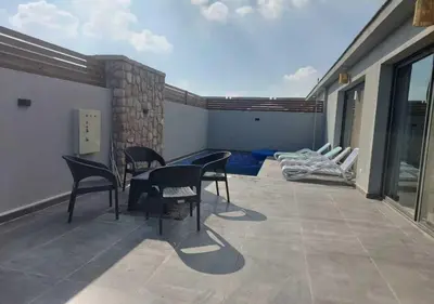 a patio with chairs and a table on a balcony at Private 2BR Apartment with Private Heated Pool at Bali D3 in Hurghada