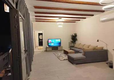 a living room with a couch and a tv at Private 2BR Apartment with Private Heated Pool at Bali D3 in Hurghada