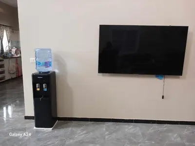 a water dispenser with a glass on a wall at Valencia Villa & Rooms in Luxor