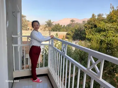 a woman standing on the balcony of a house at Valencia Villa & Rooms in Luxor