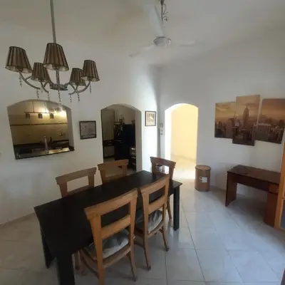 a dining room with a black table and chairs at El Fayrouz Villa in Luxor