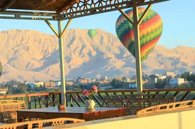 a table and chairs with a view of mountains at Holiday Dream Of Luxor in Luxor