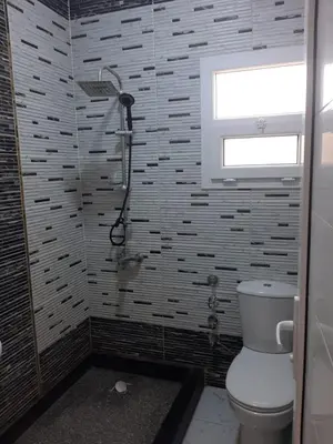 a bathroom with a shower and a toilet and a window at شقه سوبر لوكس in Hurghada