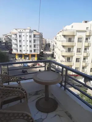 a table and chairs on a balcony with buildings at شقه سوبر لوكس in Hurghada