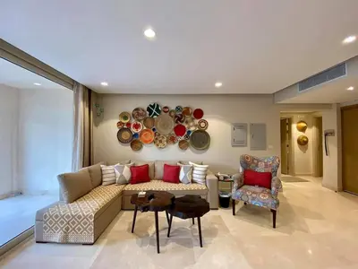 a living room with a couch and chairs and plates on the wall at 2BR Mangroovy Ground floor in Hurghada