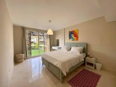 a bedroom with a bed and a large window at 2BR Mangroovy Ground floor in Hurghada