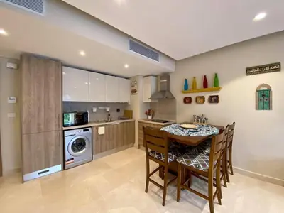 a kitchen with a table and chairs in a kitchen at 2BR Mangroovy Ground floor in Hurghada