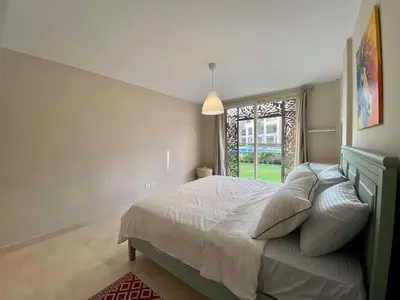 a bedroom with a bed with pillows and a window at 2BR Mangroovy Ground floor in Hurghada