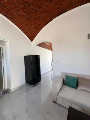 a living room with a couch and a flat screen tv at Sunrise Apartment in Hurghada