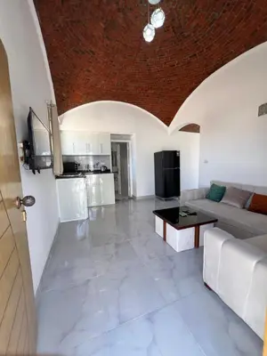a living room with a couch and a table at Sunrise Apartment in Hurghada