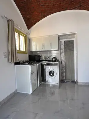 a kitchen with a stove and a washer and dryer at Sunrise Apartment in Hurghada